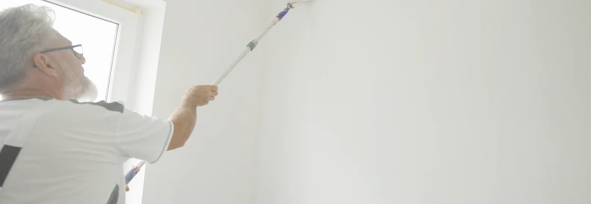 Person streicht Wand weiß